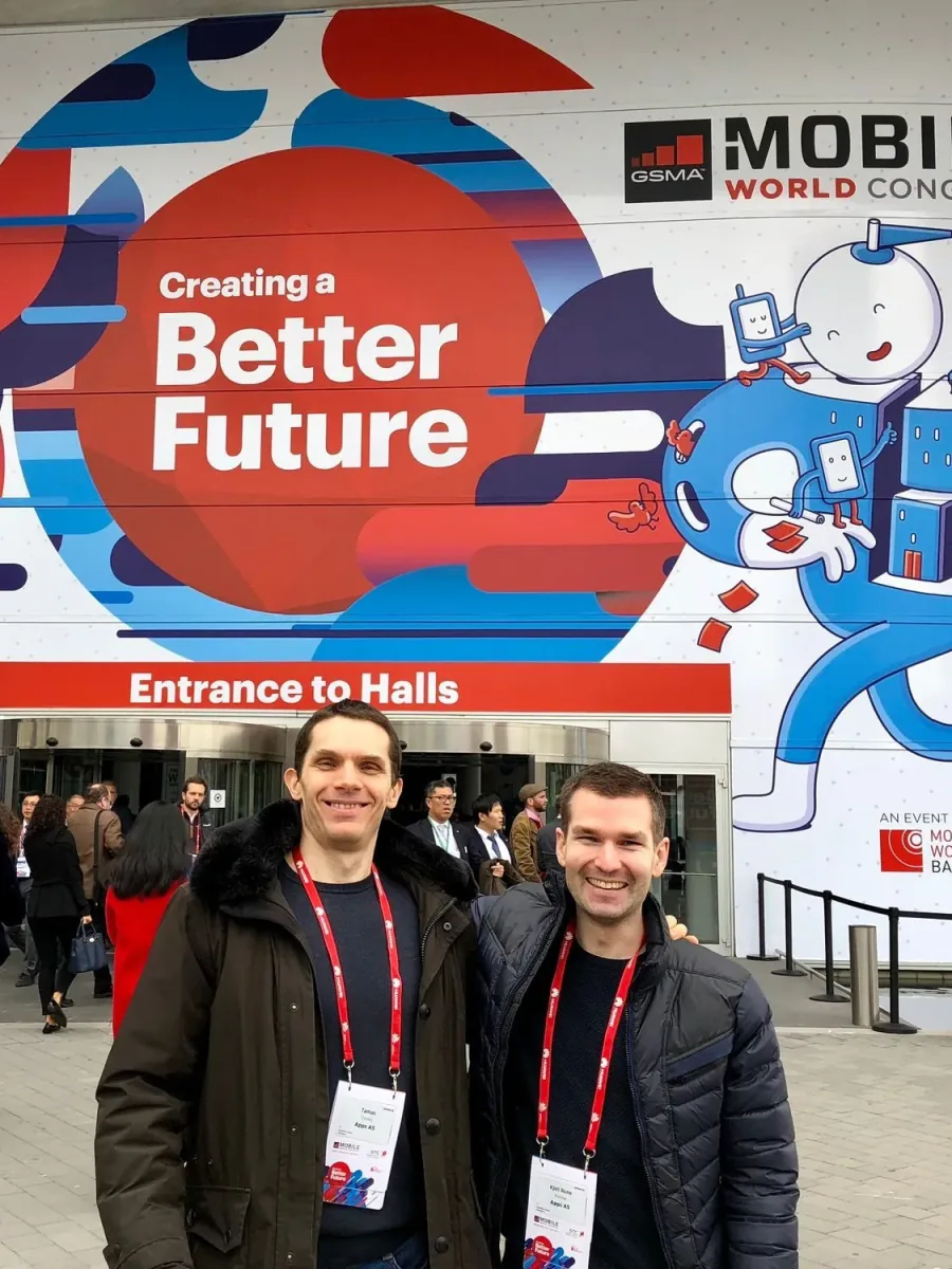 Two colleagues in lanyards outside a Mobile World Congress hall in Barcelona