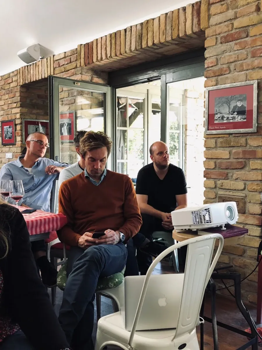 A group seated in a brick-walled room following a projector presentation